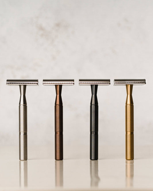 Vier Rasierhobel aus Edelstahl in 4 unterschiedlichen Farben stehen nebeneinander, von vorne fotografiert