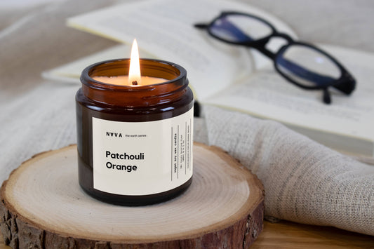 Sojakerze Orange & Verpackung auf Holzuntergrund, warme Lichtstimmung