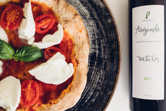 Italienische Pizza links im Bild und Olivenöl in der Falsche rechts davon