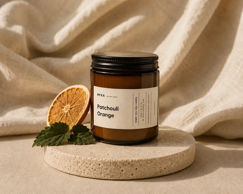 Sojakerze Patchouli Orange mit Orangenscheibe auf Steinpodest