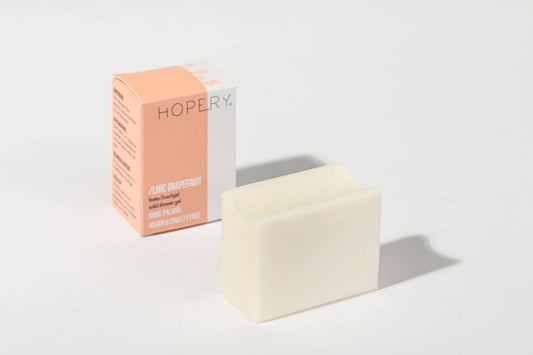 Weißer Seifenblock Lime Grapefruit neben orange-weißer Hopery Verpackung
