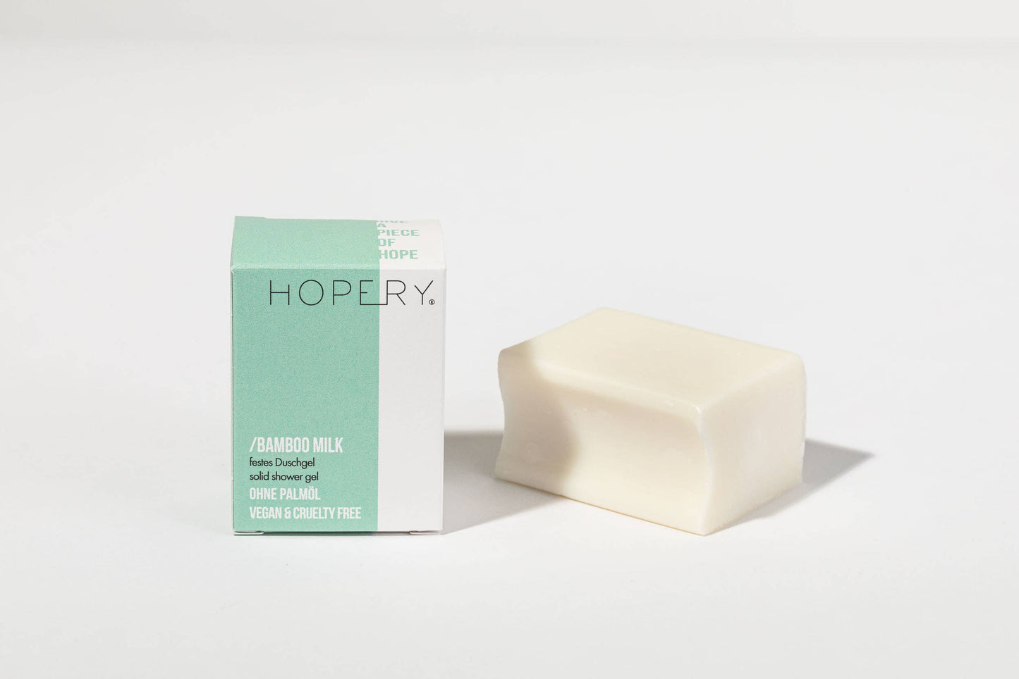 Grünes Duschgel Bamboo Milk von Hopery in rechteckiger Verpackung neben ausgepackter Form
