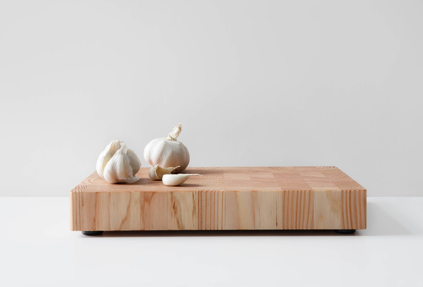 Küchenbrett aus Kiefernholz im Stirnholz-Design mit Knoblauch