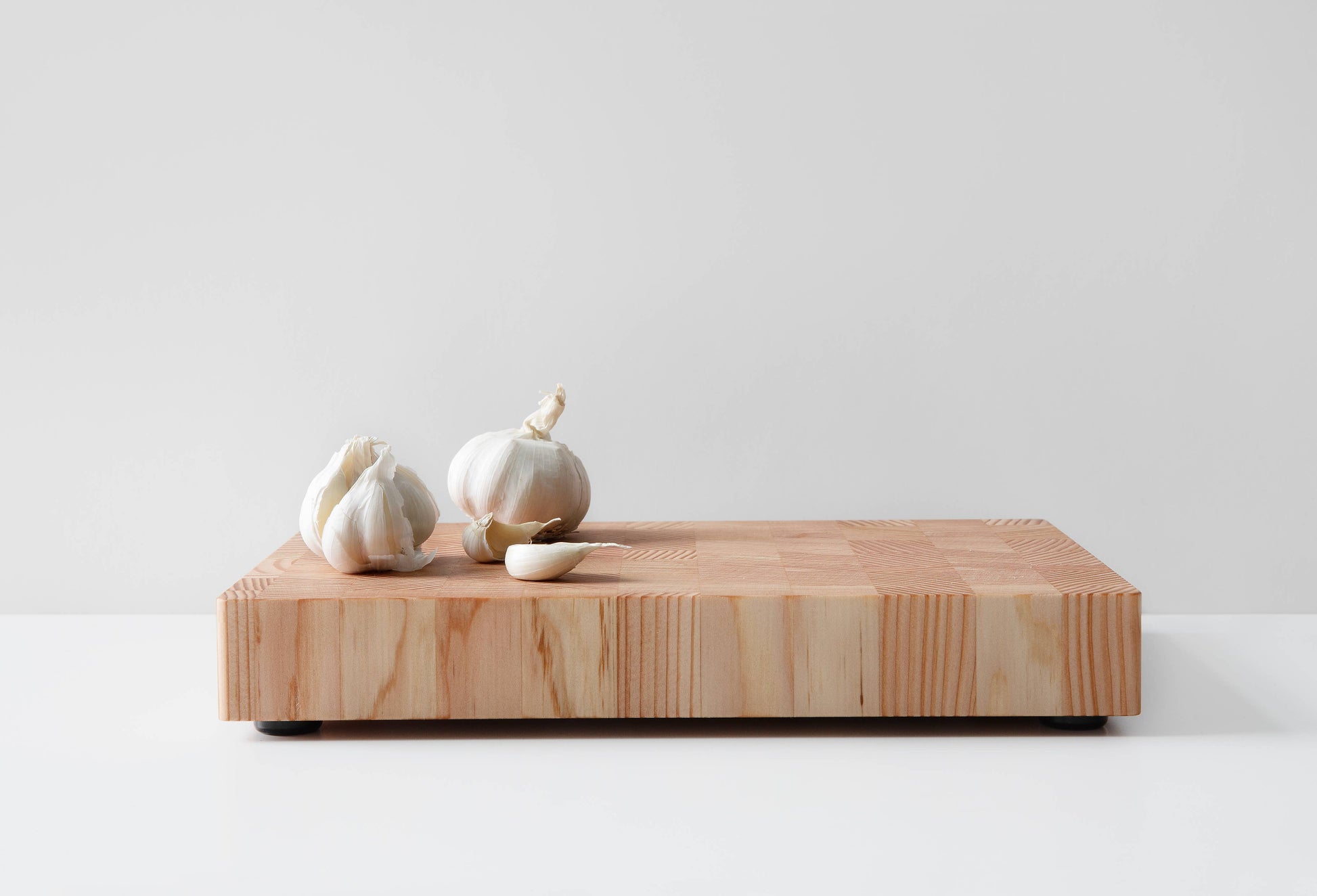 Küchenbrett aus Kiefernholz im Stirnholz-Design mit Knoblauch