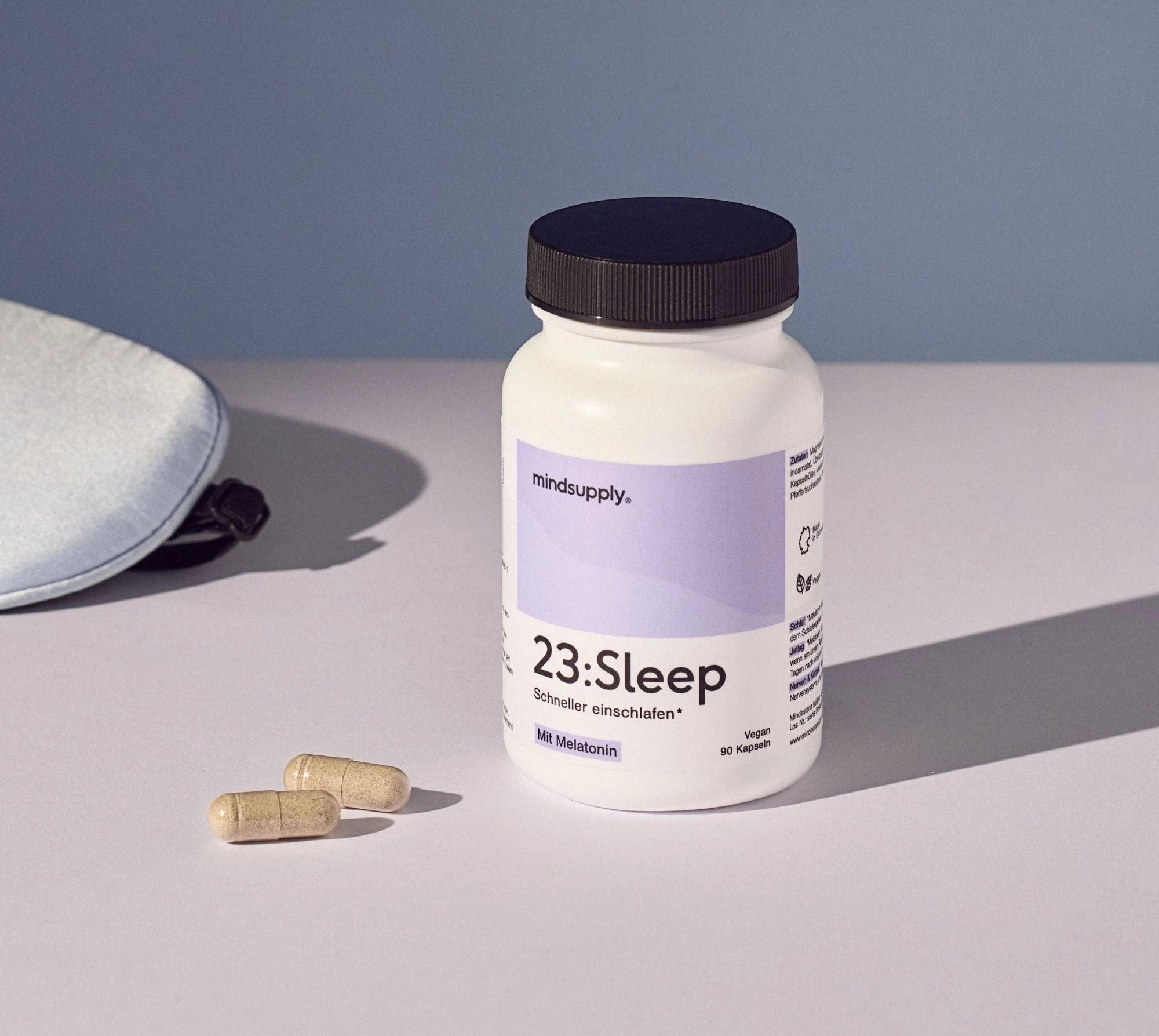 Sleep Supplement von vorne mit lila Hintergrund und Veganer Kapseln daneben 